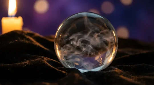 Bola de cristal transparente con reflejos de humo interior en ambiente de meditación